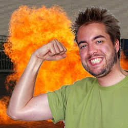 Dries Buytaert stands in front of a large, fiery explosion while flexing his muscles (original photo by Karlijn Buytaert and razzle-dazzled by Lee at Exaltation of Larks)