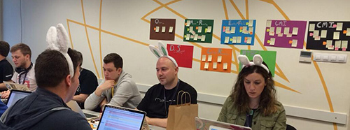 Sprinters at DevDays Szeged wearing bunny ears, in front of colored issue charts.