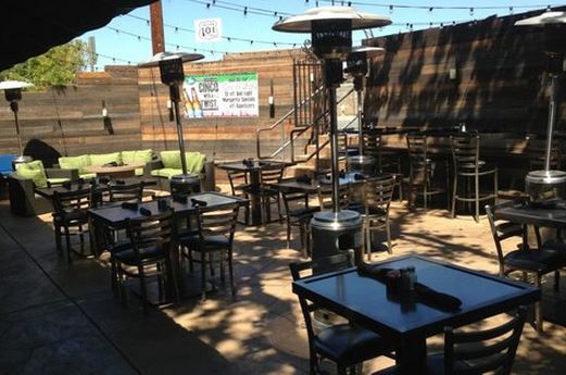 Hugo's Restaurant in Agoura Hills, CA. Outdoor patio with wooden tables and heat lamps.